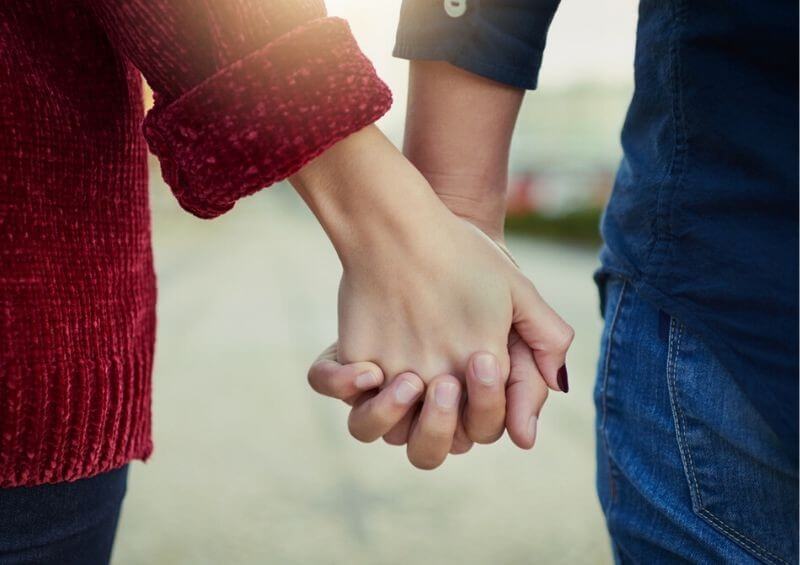 Couple holding hands in street