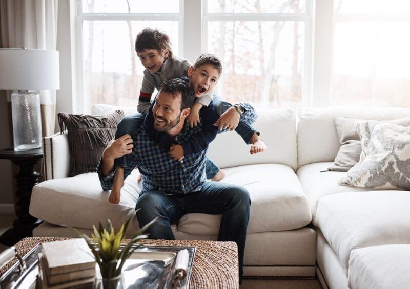 Father playing with his two children in living room