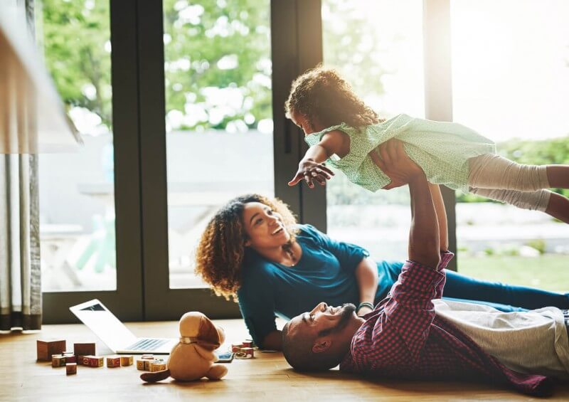 Parents playing with child indoors