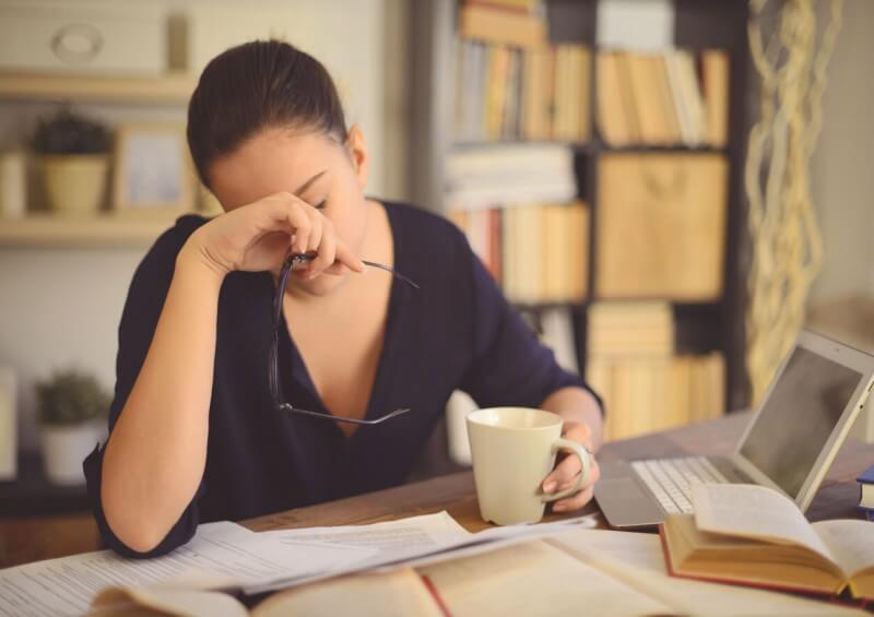 Woman sat by desk with headache